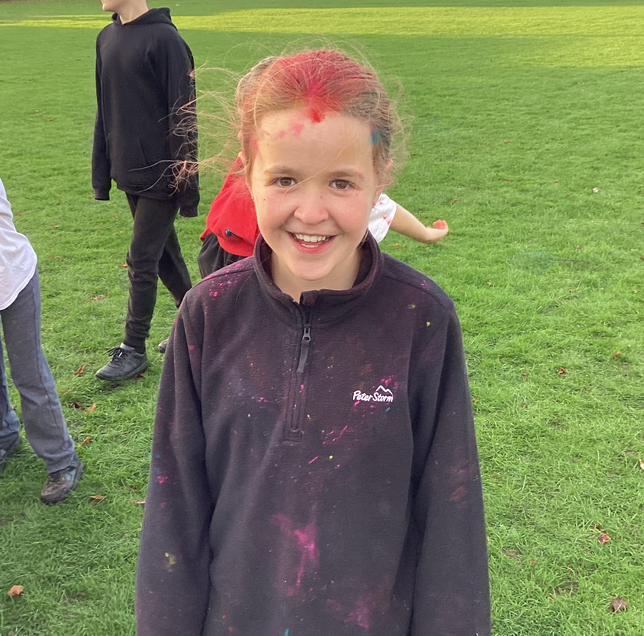 A smiling child, covered in powder paint.